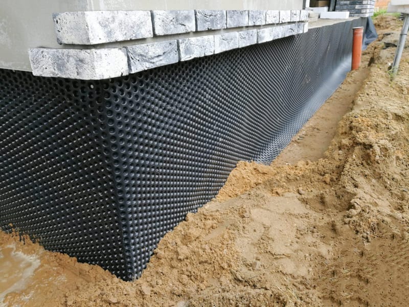 active process of waterproofing foundation of home